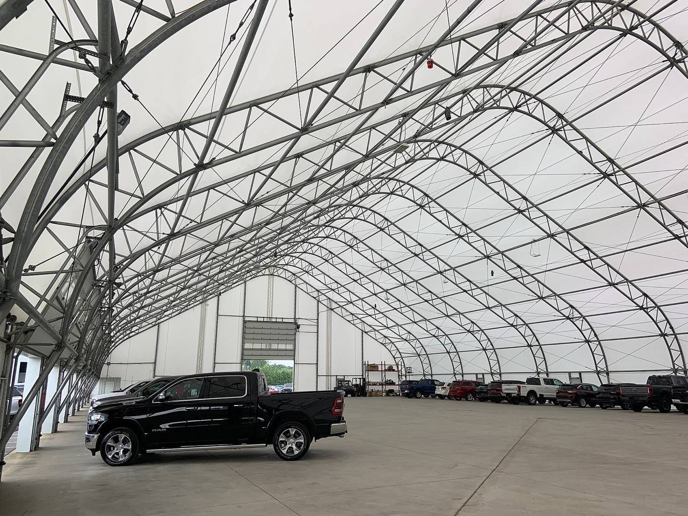 Interior of a pre-engineered fabric shelter showing the steel truss frame