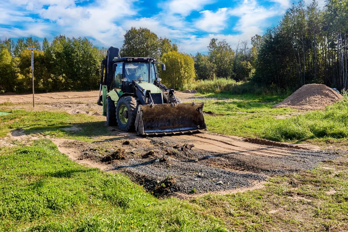 Loader grading and levelling a cleared lot