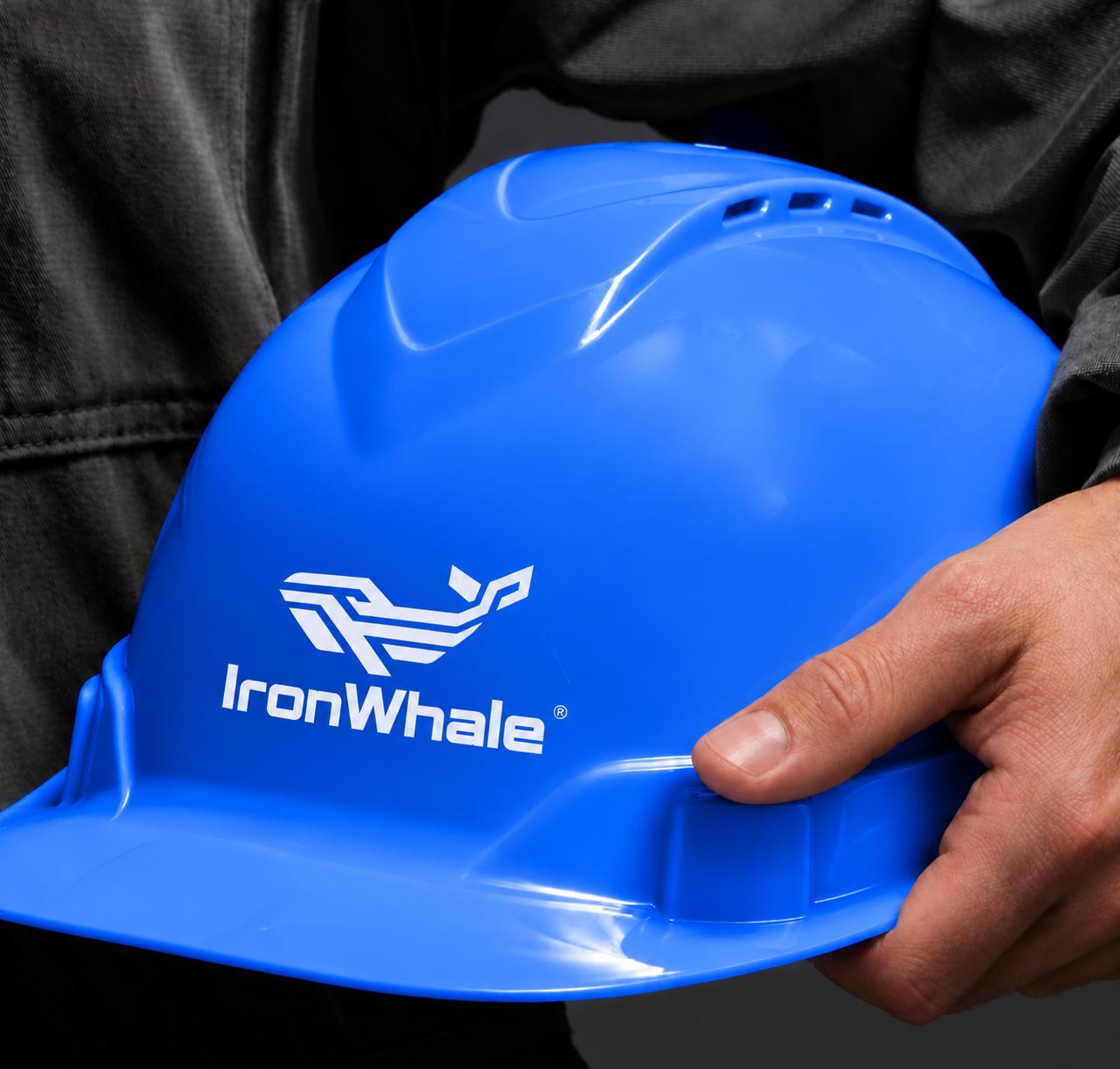 IronWhale crew member holding a blue IronWhale hard hat